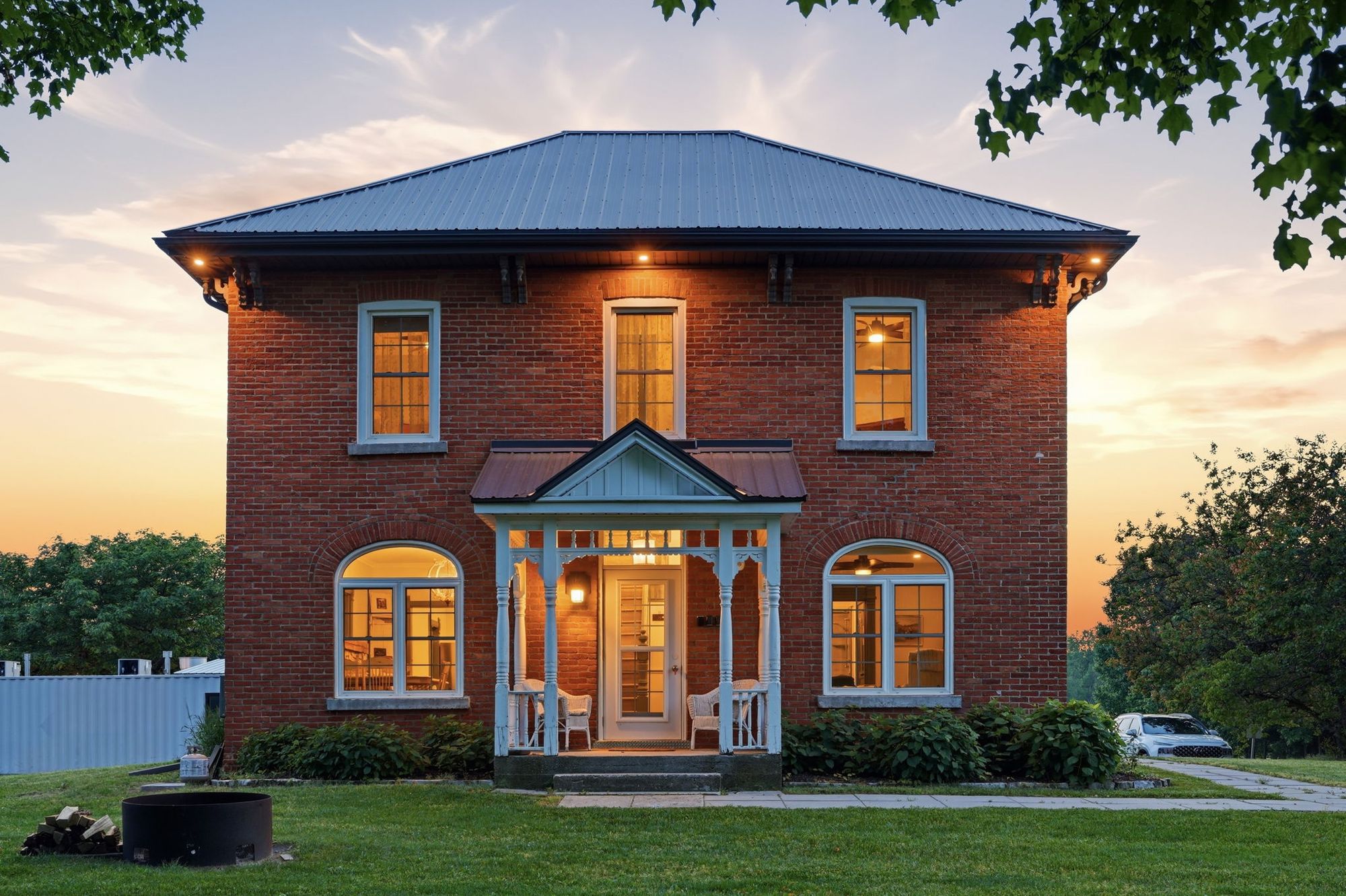 The brick guest house and its front porch at dusk