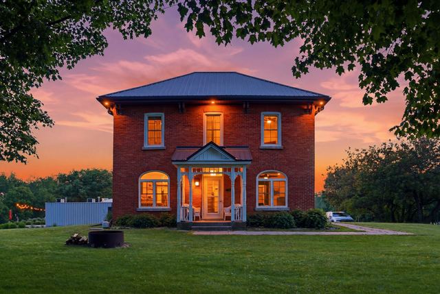 The brick guest house at dusk, its windows lit