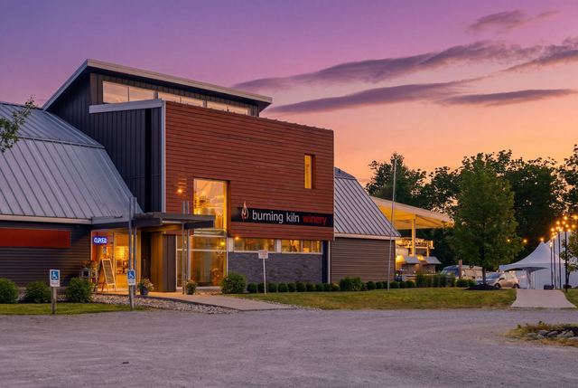 The winery building lit at dusk under a violet sky, the Burning Kiln sign glowing