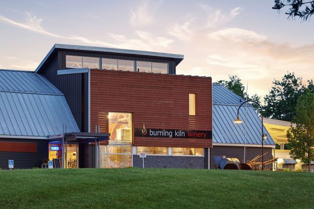 The tasting room glowing at dusk across the lawn